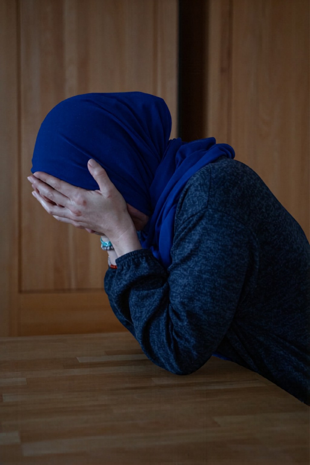 Muslimische Frau traurig mit Kopf in den erhobenen Händen